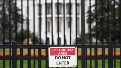 A sign is attached to the exterior fence at the South Lawn of the White House as demolition work is underway on the East Wing to begin construction on President Donald Trump's planned ballroom, in Washington, DC, on October 25, 2025.  (Photo by SAUL LOEB / AFP) (AFP)
