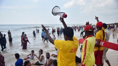 Life guards urge visitors not to venture too deep into the sea in view of 'Cyclone Montha', in Odisha's Puri (PTI) Life guards urge visitors not to venture too deep into the sea in view of 'Cyclone Montha', in Odisha's Puri (PTI)