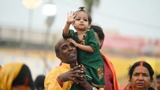 A girl sits on his father's shoulder as she witnesses Chhath Puja celebrations on Monday.(Deepak Gupta/Hindustan Times)