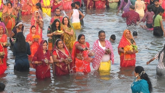 Devotees stand in water pray to the sun god on the occassion of Chhath Puja festival at Sector 42 Lake in Chandigarh on Monday.(Keshav Singh/Hindustan Times)