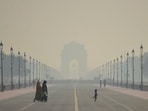 People walk along a road amid low visibility caused by worsening air quality in New Delhi. People walk along a road amid low visibility caused by worsening air quality in New Delhi.