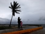 A woman and a child stand along the Kingston waterfront as hurricane Melissa approaches, in Kingston, Jamaica on October 27, 2025. 