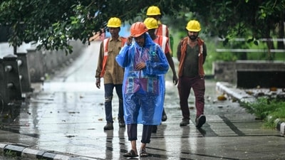 Metro site workers walk during rainfall ahead of Cyclone Montha in Chennai on October 27, 2025. (AFP) Metro site workers walk during rainfall ahead of Cyclone Montha in Chennai on October 27, 2025. (AFP)