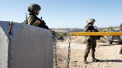 Members of the Israeli forces stand guard near a closed gate during the olive harvest in the village of Cooper, near Ramallah, in the Israeli-occupied West Bank (REUTERS/Representational)