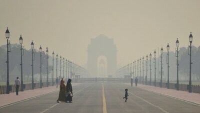People walk along a road amid low visibility caused by worsening air quality in New Delhi. (PTI) People walk along a road amid low visibility caused by worsening air quality in New Delhi. (PTI)