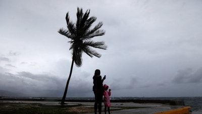 A woman and a child stand along the Kingston waterfront as hurricane Melissa approaches, in Kingston, Jamaica on October 27, 2025. (REUTERS)