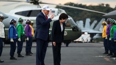 Trump gestures next to Japanese Prime Minister Sanae Takaichi as they are welcomed by U.S. Navy Rainbow Side Boys, aboard the aircraft carrier USS George Washington, during a visit to U.S. Navy's Yokosuka base in Yokosuka, Japan, October 28, 2025. REUTERS/Evelyn Hockstein (REUTERS)
