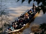 People from various countries, who were working in the KK Park compound in Myanmar, travel in a boat across the Moei river to cross over from Myanmar to Thailand, as seen from Mae Sot District, Tak Province area on October 24, 2025. 