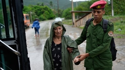 A soldier helps a woman evacuate before the arrival of Hurricane Melissa in Canizo, a community in Santiago de Cuba, Tuesday, Oct. 28, 2025. (AP Photo/Ramon Espinosa) (AP) A soldier helps a woman evacuate before the arrival of Hurricane Melissa in Canizo, a community in Santiago de Cuba, Tuesday, Oct. 28, 2025. (AP Photo/Ramon Espinosa) (AP)