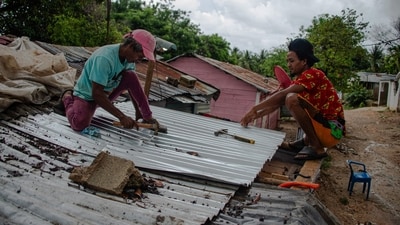 Two man fix the roof of a house ahead of the arrival of Hurricane Melissa in Barahona, Dominican Republic on October 28, 2025. (Photo by Carlos FABAL / AFP) (AFP) Two man fix the roof of a house ahead of the arrival of Hurricane Melissa in Barahona, Dominican Republic on October 28, 2025. (Photo by Carlos FABAL / AFP) (AFP)