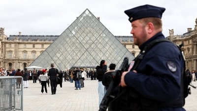 A French CRS riot police officer patrols near the glass Pyramid of the Louvre Museum, after French police arrested suspects in the Louvre heist case, in Paris, France. (REUTERS)