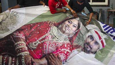 Family members of Raja Raghuvanshi, who was allegedly murdered during his honeymoon in Meghalaya, cut out the picture of his wife Sonam Raghuvanshi from a poster of their marriage after she was accused of plotting his murder. (PTI FILE PHOTO) Family members of Raja Raghuvanshi, who was allegedly murdered during his honeymoon in Meghalaya, cut out the picture of his wife Sonam Raghuvanshi from a poster of their marriage after she was accused of plotting his murder. (PTI FILE PHOTO)