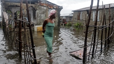 A woman stands outside her home after heavy rains from the outer bands of Hurricane Melissa flooded parts of Les Cayes, Haiti, October 29, 2025. (REUTERS)