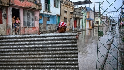 A resident holds a piece of a roof before Hurricane Melissa hits the city of Santiago de Cuba, Cuba, on October 28, 2025. (Photo by YAMIL LAGE / AFP) (AFP) A resident holds a piece of a roof before Hurricane Melissa hits the city of Santiago de Cuba, Cuba, on October 28, 2025. (Photo by YAMIL LAGE / AFP) (AFP)