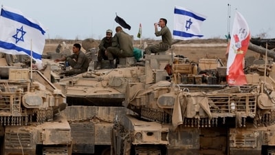Israeli soldiers sit on military vehicles near the Israel-Gaza border, Oct. 12. Israeli soldiers sit on military vehicles near the Israel-Gaza border, Oct. 12.