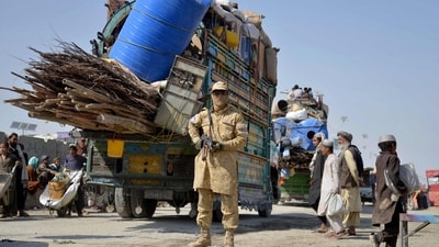 A Taliban security personnel stands guard as deported Afghan refugees from Pakistan arrive at the zero-point border crossing between Afghanistan and Pakistan (AFP) A Taliban security personnel stands guard as deported Afghan refugees from Pakistan arrive at the zero-point border crossing between Afghanistan and Pakistan (AFP)