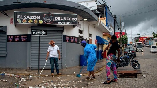 People clean a street ahead of the arrival of Hurricane Melissa in Barahona, Dominican Republic on October 28, 2025. (Photo by Carlos FABAL / AFP)(AFP)