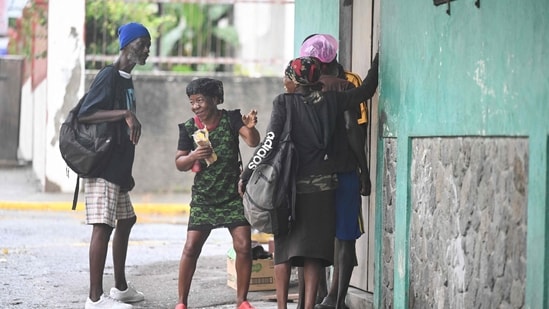 Homeless persons gather to get a hot meal at a Missionaries of the Poor location in Kingston on October 27, 2025.&nbsp;(AFP)