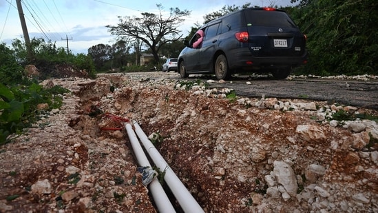 Hurricane Melissa ripped up trees and knocked out power after making landfall in Jamaica on October 28, 2025 as one of the most powerful hurricanes on record, inundating the island nation with rains that threaten flash floods and landslides. Road infrastructure is seen damaged on Spur Tree Hill main road following the passage of Hurricane Melissa in Manchester, Jamaica, on October 28, 2025. (Photo by Ricardo Makyn / AFP)(AFP)