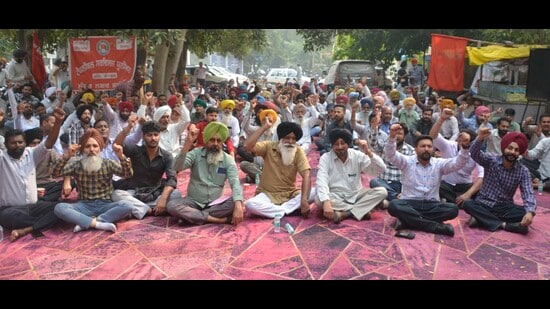 PSPCL employees protesting against the Optimum Use of Vacant Government Lands scheme outside the chief engineer's office in Ludhiana on Wednesday. (Manish/HT)