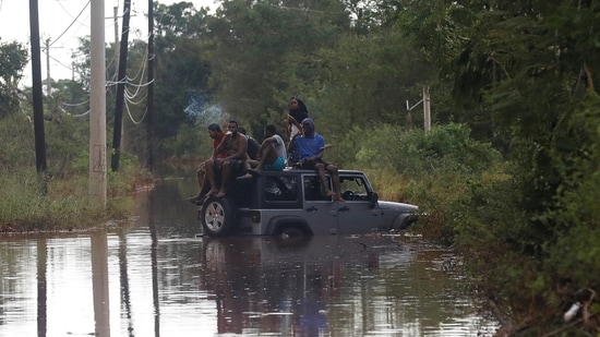 People sit on the roof of a vehicle riding on a flooded road, after Hurricane Melissa made landfall, in Prospect, Manchester, Jamaica, October 29, 2025. REUTERS/Octavio Jones(REUTERS)