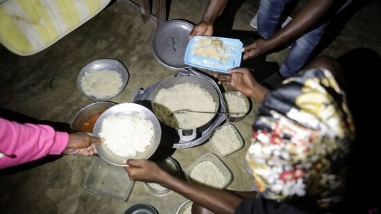 People receive food at a school turned shelter while Haiti is seeing downpours from the outer bands of Hurricane Melissa, as the storm is churning towards Cuba, after making landfall in Jamaica, in Les Cayes, Haiti, October 28, 2025. REUTERS/Patrice Noel(REUTERS)