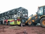 A JCB pulling charred remains of a bus caught fire following a collision with a two-wheeler near the Chinnatekur village, in Kurnool on Friday. (ANI Video Grab) A JCB pulling charred remains of a bus caught fire following a collision with a two-wheeler near the Chinnatekur village, in Kurnool on Friday. (ANI Video Grab)