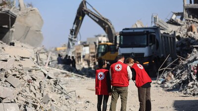 Red Cross members in Gaza City on Monday as heavy machinery removed rubble. Red Cross members in Gaza City on Monday as heavy machinery removed rubble.