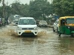A car wading through a waterlogged stretch on the road in Sector 69 in Gurugram. (HT Photo)