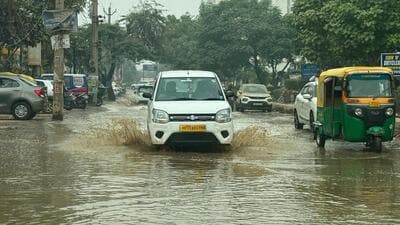 A car wading through a waterlogged stretch on the road in Sector 69 in Gurugram. (HT Photo) A car wading through a waterlogged stretch on the road in Sector 69 in Gurugram. (HT Photo)
