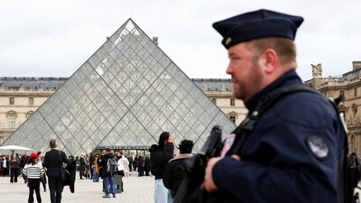 A French CRS riot police officer patrols near the glass Pyramid of the Louvre Museum, after French police arrested suspects in the Louvre heist case, in Paris, France. (REUTERS)