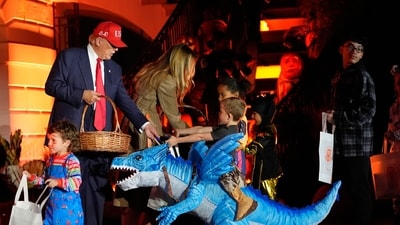 Trump and Melania handed out candy to a child dressed as riding a dinosaur during the White House Halloween event. (AP Photo/Alex Brandon) (AP) Trump and Melania handed out candy to a child dressed as riding a dinosaur during the White House Halloween event. (AP Photo/Alex Brandon) (AP)