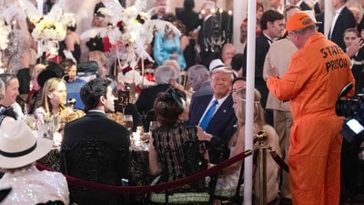 Trump looks at a guest dressed in prison garbs during a Halloween party at his Mar-a-Lago residence in Palm Beach, Florida, on October 31, 2025. (Photo by ROBERTO SCHMIDT / AFP) (AFP) Trump looks at a guest dressed in prison garbs during a Halloween party at his Mar-a-Lago residence in Palm Beach, Florida, on October 31, 2025. (Photo by ROBERTO SCHMIDT / AFP) (AFP)