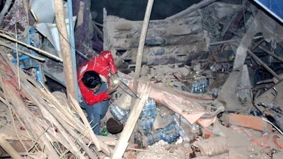 A Afghan Red Crescent rescue worker seen sifting through the destruction and rubble after a 6.3 earthquake struck Afghanistan's Balkh province on Monday (REUTERS)