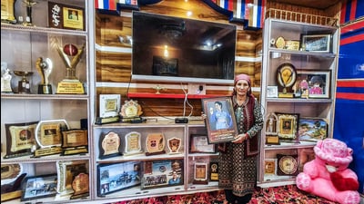 Cricketer Renuka Thakur's mother Sunita Thakur poses for a picture with her daughter’s accolades, in Shimla on Monday. (ANI) Cricketer Renuka Thakur's mother Sunita Thakur poses for a picture with her daughter’s accolades, in Shimla on Monday. (ANI)