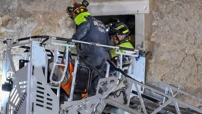 Firefighters pull a construction worker from under the debris of a medieval tower, which was under renovation near the Roman Forum in Rome (AP)