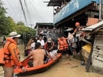 This handout photo taken and released on November 4, 2025 by the Philippine Coast Guard (PCG) shows coast guard personnel evacuating people from their flooded homes following heavy rains brought about by Typhoon Kalmaegi in Cebu province, central Philippines.
