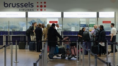 Passengers wait in line at a service desk at Brussels Airport after the Belgian air traffic control service reported a sighting of a drone, in Zaventem, Belgium. (Reuters)