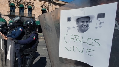 Police officers stand guard as protesters demonstrate against the assassination of Uruapan's mayor at the Government Palace in Morelia, Michoacan state, Mexico, on November 3, 2025. The Mexican government reported on November 2 that the mayor of Uruapan, Carlos Manzo, who was killed the previous night during a public event in the western state of Michoacan, had been under official protection since December last year. (Photo by Jordi LEBRIJA / AFP) (AFP) Police officers stand guard as protesters demonstrate against the assassination of Uruapan's mayor at the Government Palace in Morelia, Michoacan state, Mexico, on November 3, 2025. The Mexican government reported on November 2 that the mayor of Uruapan, Carlos Manzo, who was killed the previous night during a public event in the western state of Michoacan, had been under official protection since December last year. (Photo by Jordi LEBRIJA / AFP) (AFP)