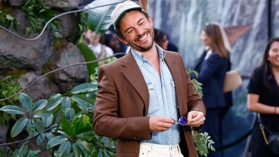The charming actor was all smiles at the London premiere of Jurassic World: Rebirth in June 2025, slaying a unique ensemble featuring a brown double-breasted, structured jacket, paired with a light blue denim shirt underneath, white trousers, and a tennis cap. (AP)