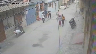 The CCTV footage of the incident shows the boy waiting near a motorbike as the girl walks on opposite side while speaking on the phone. (X/PTI) The CCTV footage of the incident shows the boy waiting near a motorbike as the girl walks on opposite side while speaking on the phone. (X/PTI)