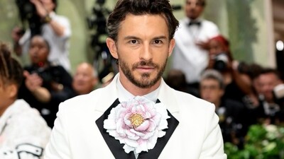 Jonathan Bailey channeled all of Anthony Bridgerton's charm in 2024's Met Gala, wearing a white double-breasted white jacket with black satin lapels from Loewe, and a gigantic flower for a bow-tie. (x/@omegawatches)