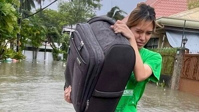 A resident navigates a flooded street as they evacuate to safer grounds as Typhoon Kalmaegi affects Cebu city, central Philippines. (AP)