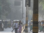 People walk through heavy dust pollution caused by the poor condition of Sarojini Nagar Road, in New Delhi, India. People walk through heavy dust pollution caused by the poor condition of Sarojini Nagar Road, in New Delhi, India.