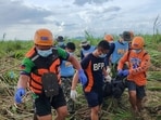Rescuers carry a body bag containing the body of a victim of Typhoon Kalmaegi amongst sugar plantation at a village in Isabela town, Negros Oriental province, central Philippines. 