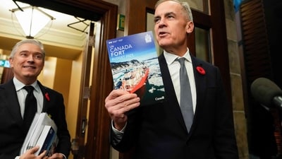 Canada's Prime Minister Mark Carney holds up a copy of the budget as he and Minister of Finance and National Revenue Francois-Philippe Champagne. (AP) Canada's Prime Minister Mark Carney holds up a copy of the budget as he and Minister of Finance and National Revenue Francois-Philippe Champagne. (AP)