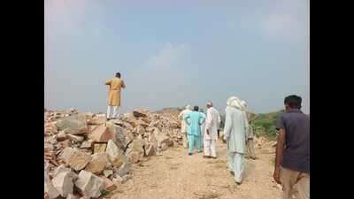 Locals at the site in Gudana village where rocks have been mined illegally on their side of the hillock. (HT Photo) Locals at the site in Gudana village where rocks have been mined illegally on their side of the hillock. (HT Photo)