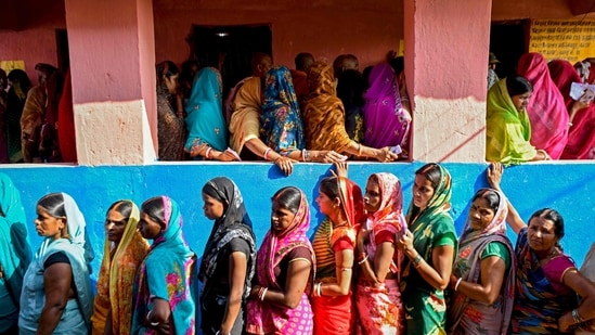 Women voters stand in queues to cast their ballots at a polling station during the first phase of voting for assembly elections on November 6, 2025, at the Raghopur constituency in Vaishali district of Bihar.