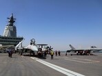 Crew members work on carrier-based aircraft from left, J-15T jet fighter, KJ-600 AWACS and J-35 stealth fighter jet on the flight deck of China's third conventionally powered aircraft carrier, the Fujian.