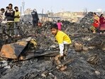 New Delhi: A child sifts through charred remains after a fire broke out spreading to around 500 shanties near Rithala metro station, at Rohini area, in New Delhi.